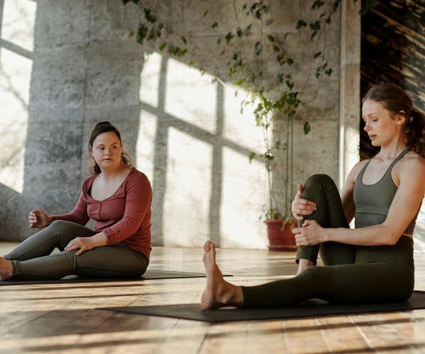 Person stretching gently in a sunlit room, feeling peaceful.
